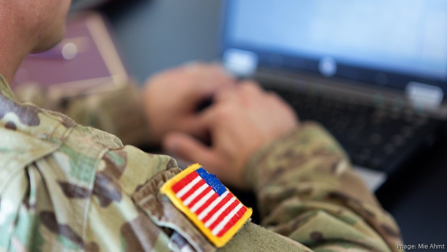 A man wearing a camoflauge uniform with USA flag patch on the shoulder