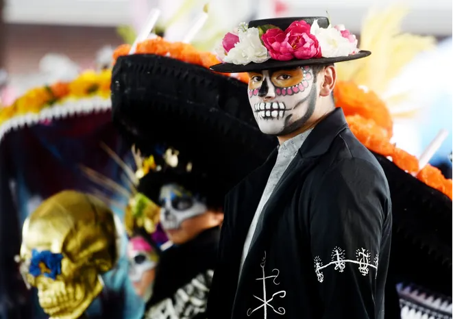 A man with Day of the Dead face paint, hat and jacket